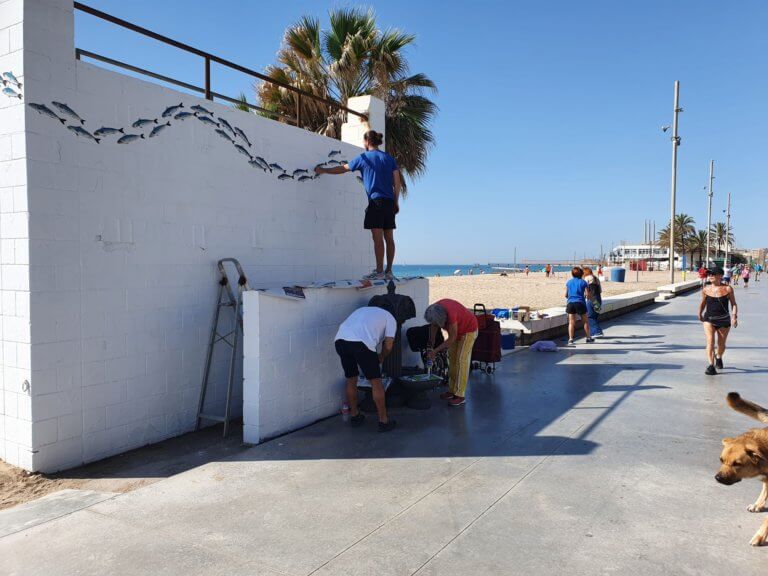 Una iniciativa popular restaura i pinta peixos a les estructures de la platja