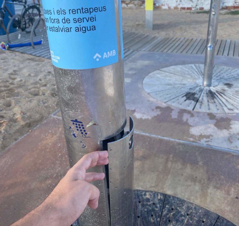 Banyistes manipulen una de les dutxes de la platja de Badalona perquè funcioni